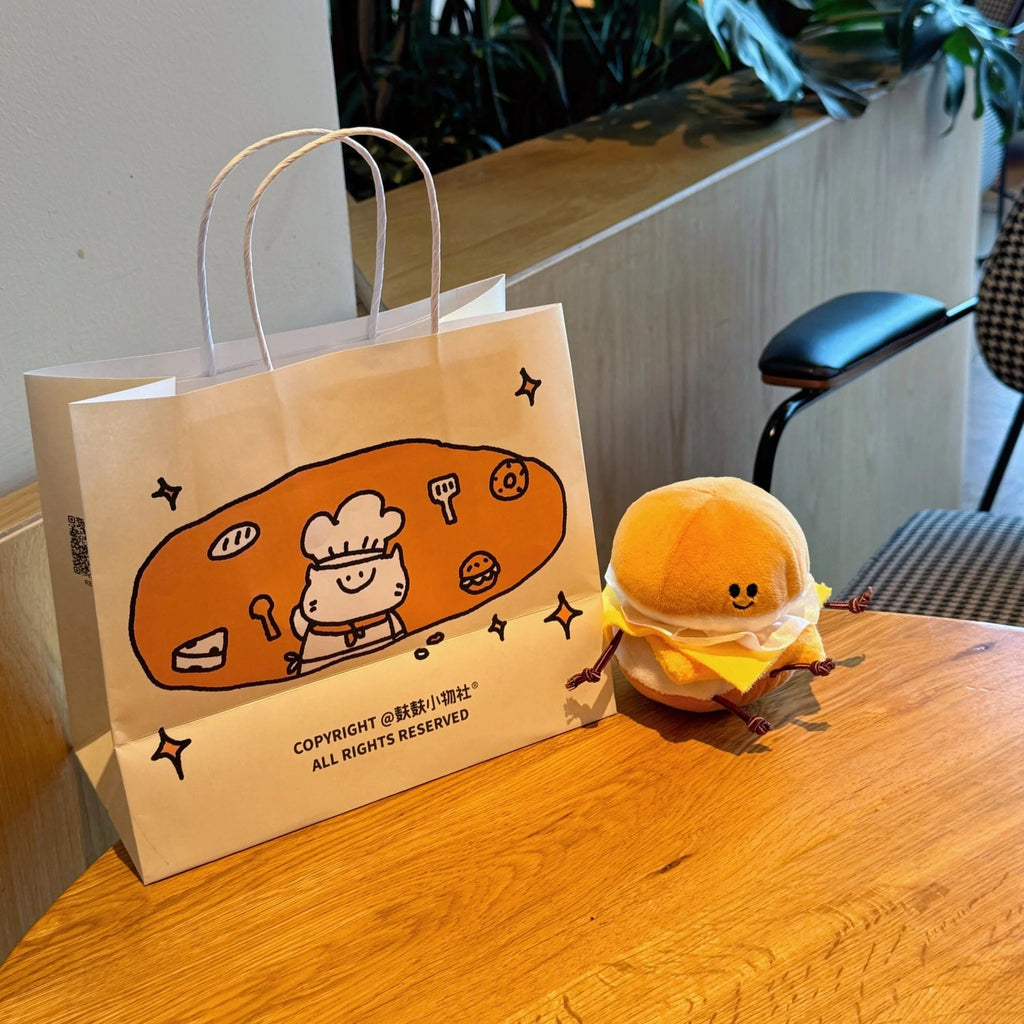 Plush burger toy clipped to backpack